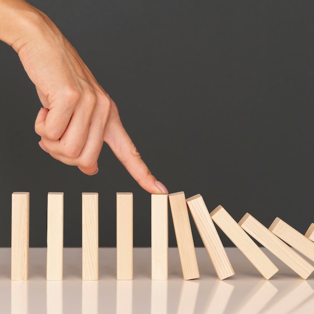 Domino game made with wooden pieces representing finances struggles