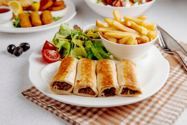 Free photo doner wrapped in lavsh with fries on plate