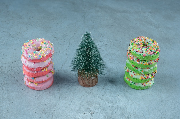 Free photo donut stacks and a tree figurine on marble.