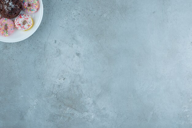 Donuts and a chocolate on a platter on marble background. High quality photo