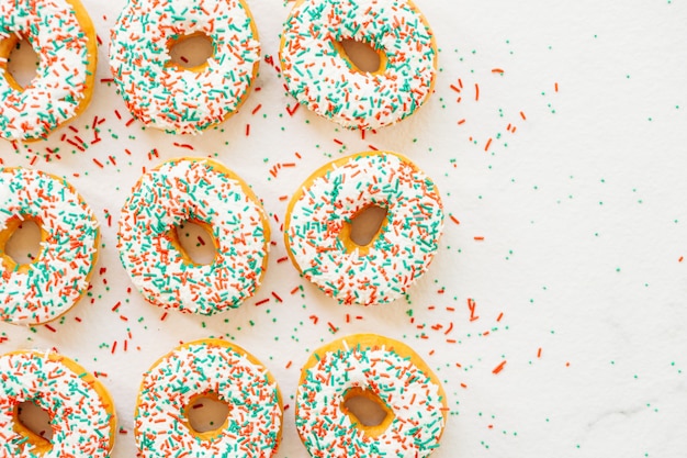 Free photo donuts with white chocolate cream and sprinkles sugar