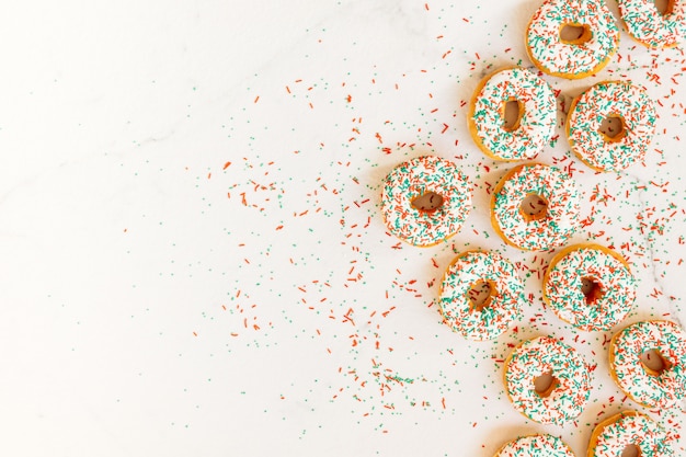 Free photo donuts with white chocolate cream and sprinkles sugar