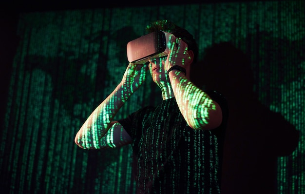 Free Photo double exposure of a caucasian man and virtual reality vr headset is presumably a gamer or a hacker cracking the code into a secure network or server, with lines of code in green