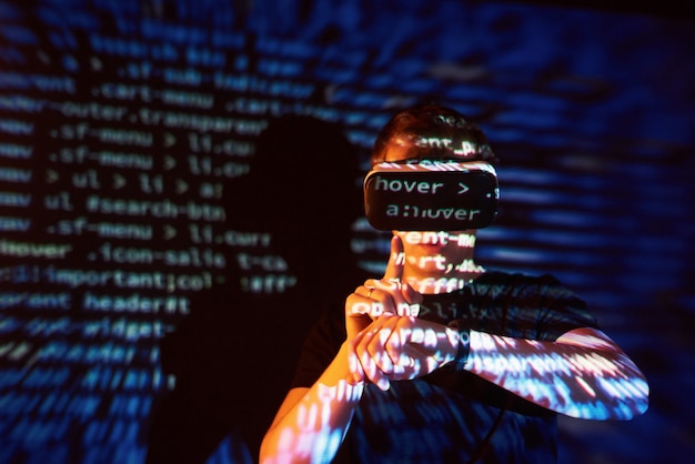 Free photo double exposure of a caucasian man and virtual reality vr headset is presumably a gamer or a hacker cracking the code into a secure network or server, with lines of code