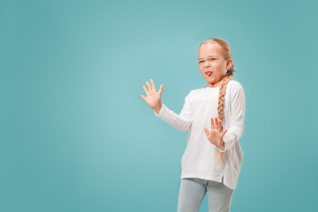 Doubtful pensive teen girl rejecting something against blue