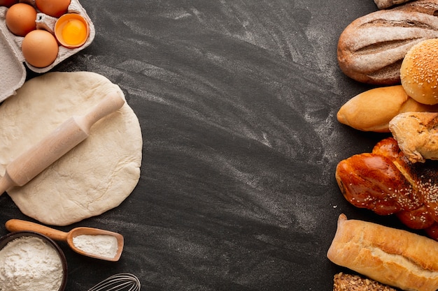 Dough with rolling pin and assortment of bread