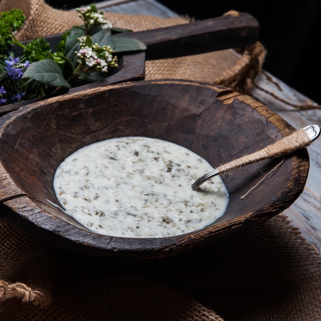 Free photo dovga with flowers and spoon in wooden plate