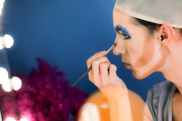 Drag person putting on makeup