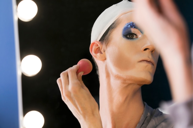 Free photo drag person putting on makeup