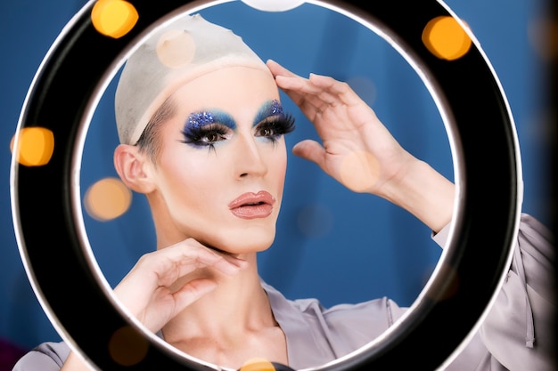 Free photo drag person putting on makeup