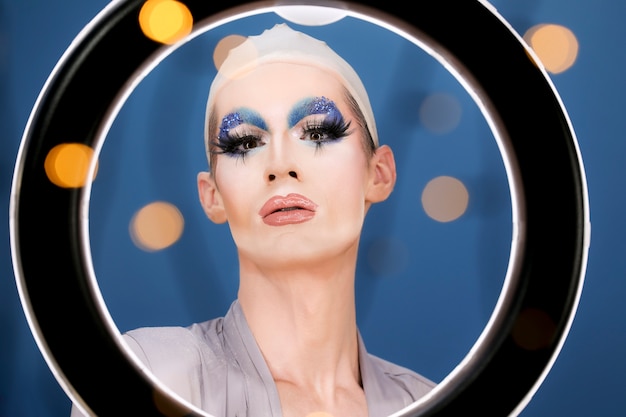 Free photo drag person putting on makeup