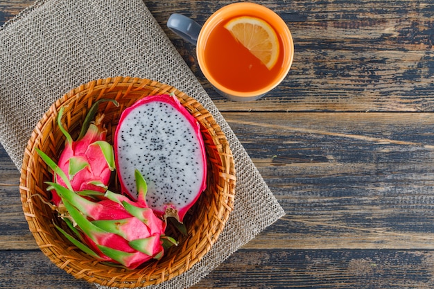 Dragon fruit in a basket with tea top view on wooden table