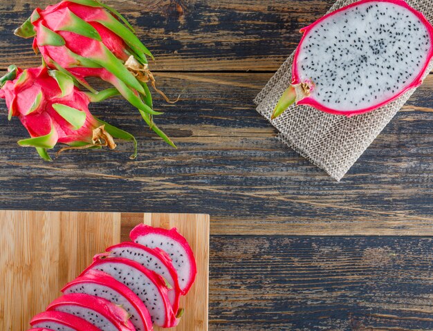 Dragon fruit with cutting board flat lay on wooden table