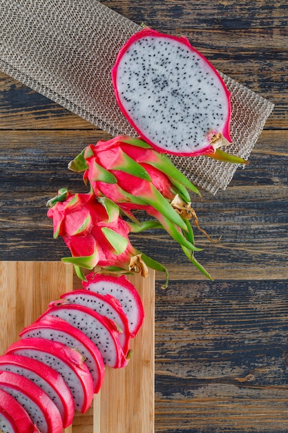 Free Photo dragon fruit with cutting board on wooden table, top view.