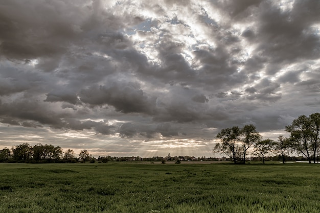 Dramatic landscape view with sun rays shining through a dark cloudy sky