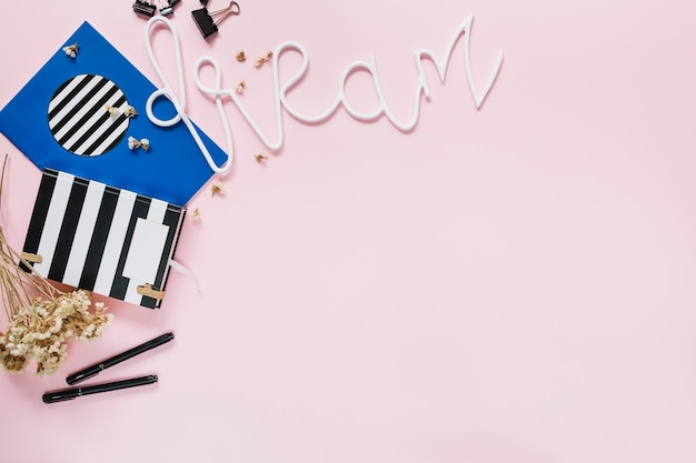 Dream text with stationery and flowers on pink backdrop