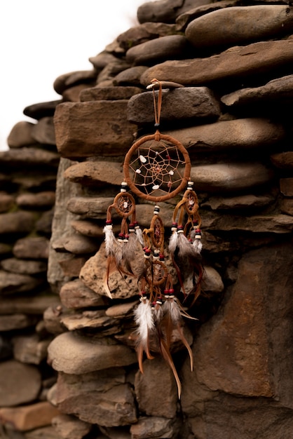 Free Photo dreamcatcher hanging from a rock