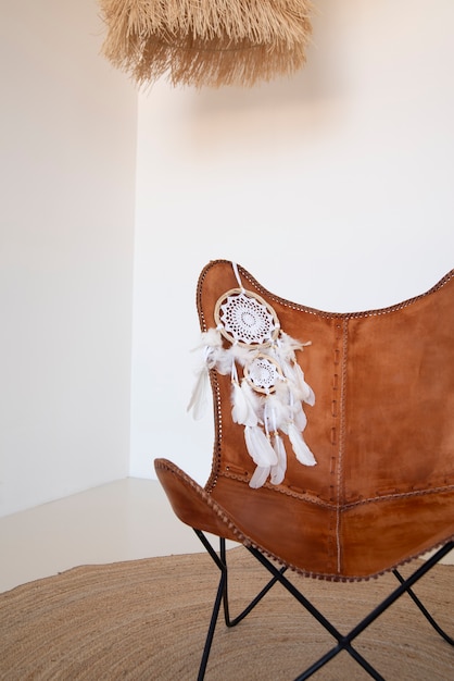 Free photo dreamcatcher placed on the backrest of a leather chair