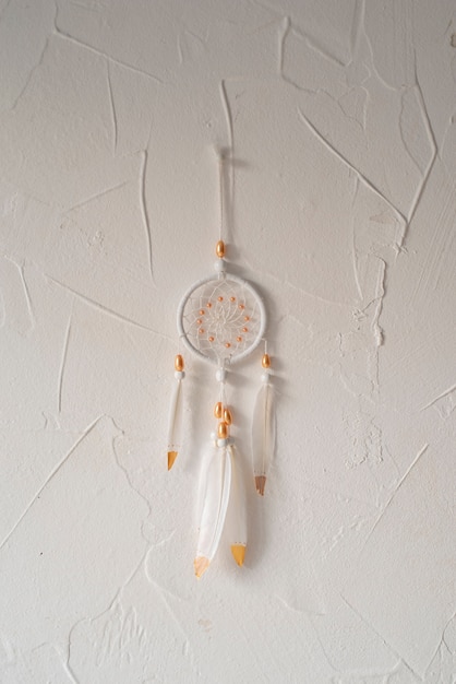 Free photo dreamcatcher placed on a white wall