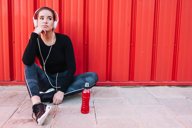 Free photo dreaming sportive girl in headphones on pavement