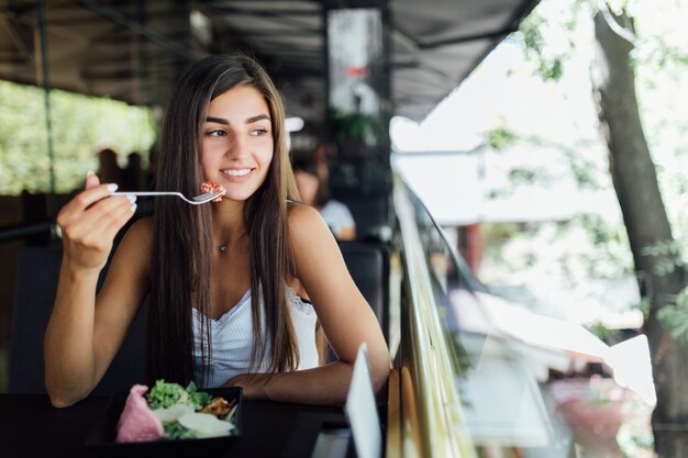 Dreaming woman eating healthy food sitting in the beautiful interior