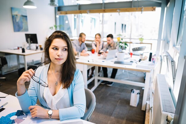 Free Photo dreamy businesswoman in office