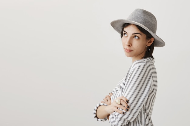 Free photo dreamy cute girl in grey hat looking upper left corner