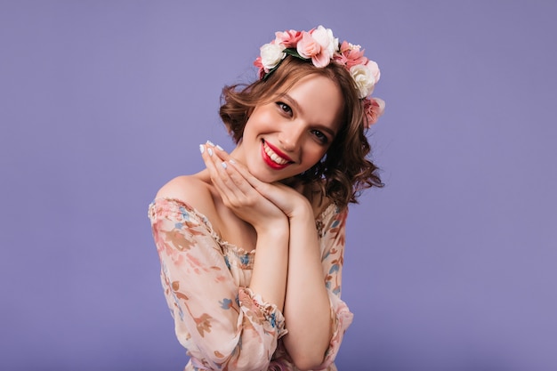 Dreamy female model with beautiful smile posing. pretty curly girl with roses in hair.