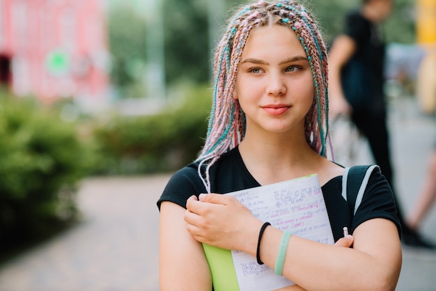 Dreamy girl embracing textbook