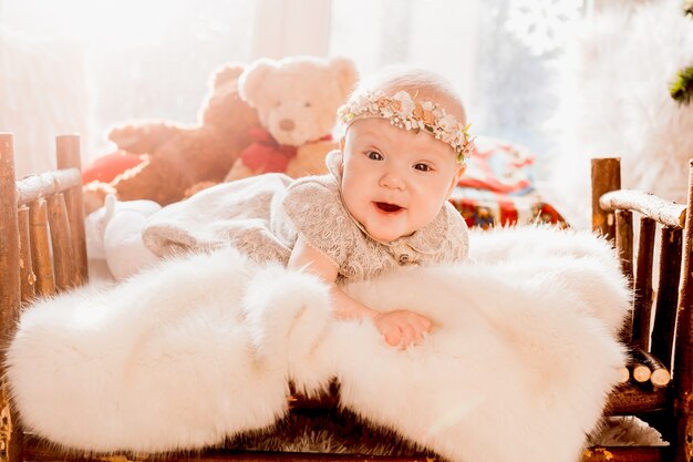 Dreamy little girl lies on fluffy blanket in a bed 