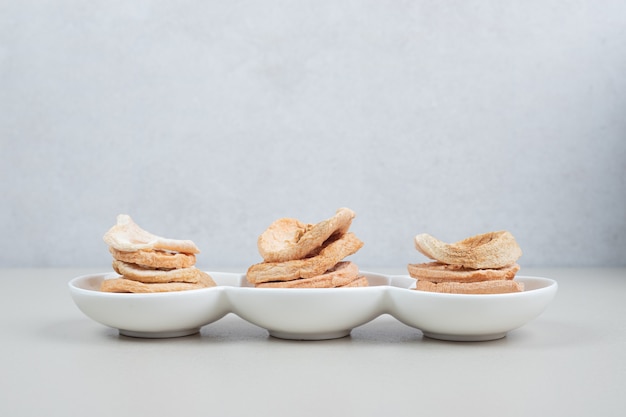 Dried apple slices on white plate