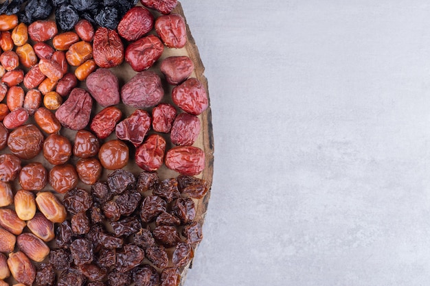 Dried cherries, berries and dates on a wooden platter. High quality photo