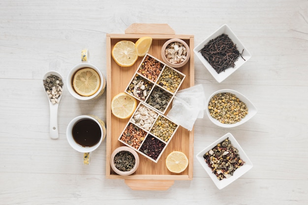 Free Photo dried chinese chrysanthemum flowers; herbs; tea and lemon slices on wooden tray