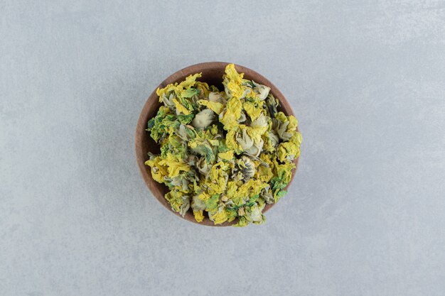 Dried chrysanthemum flowers in wooden bowl.  