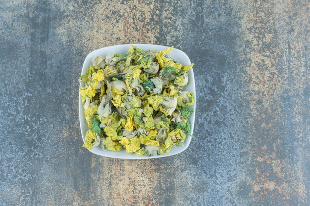 Dried chrysanthemum petals on white plate.