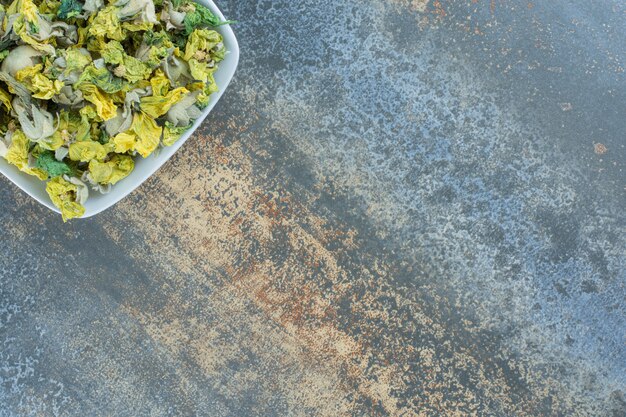 Dried chrysanthemum petals on white plate.