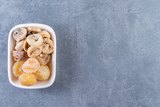 Free photo dried figs in a bowl on the marble surface