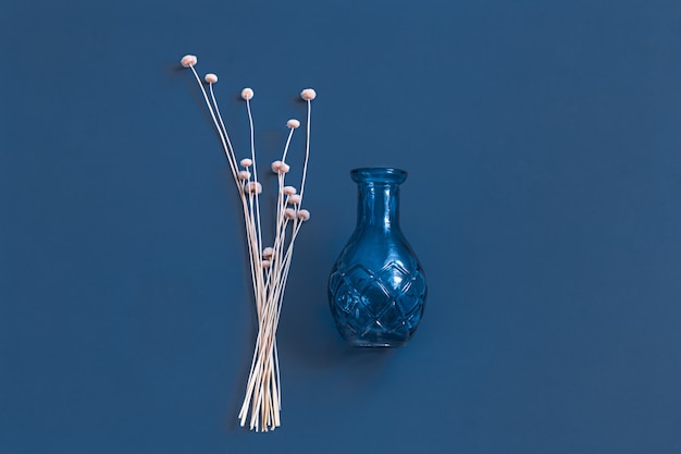 Free photo dried flowers and a vase on blue.