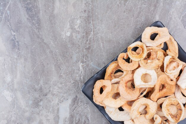 Dried healthy apples on dark plate.