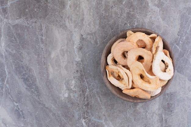 Free photo dried healthy apples on wooden plate.