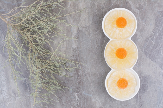 Free photo dried healthy fruits with sweet marmalade on marble background.