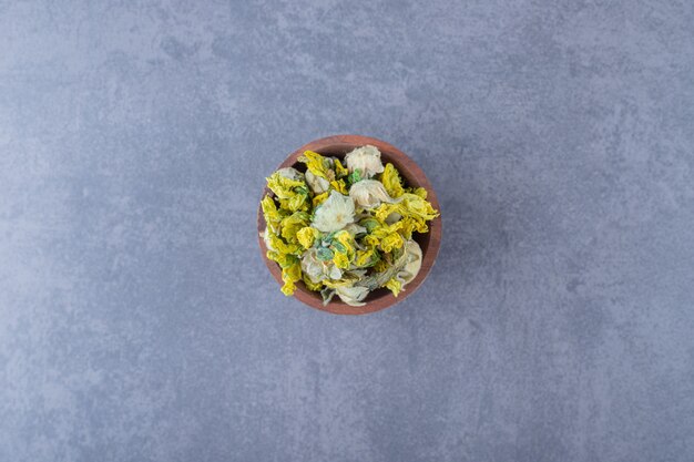 Dried heathy herbs in wooden bowl . top view.