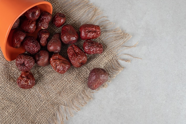 Free photo dried indian jujube berries in a cup on concrete.