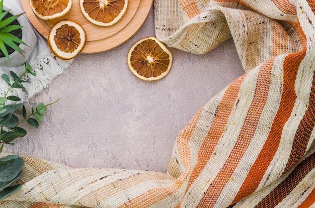 Free photo dried lemon slices with stripes textile on concrete backdrop