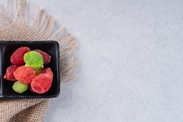 Free photo dried multicolor fruit jellies isolated on concrete background.