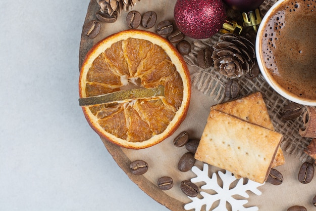 Dried orange with aroma cup of coffee on wooden plate . High quality photo