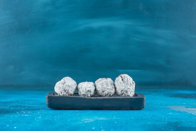 Dried persimmon on a wooden plate on the blue surface