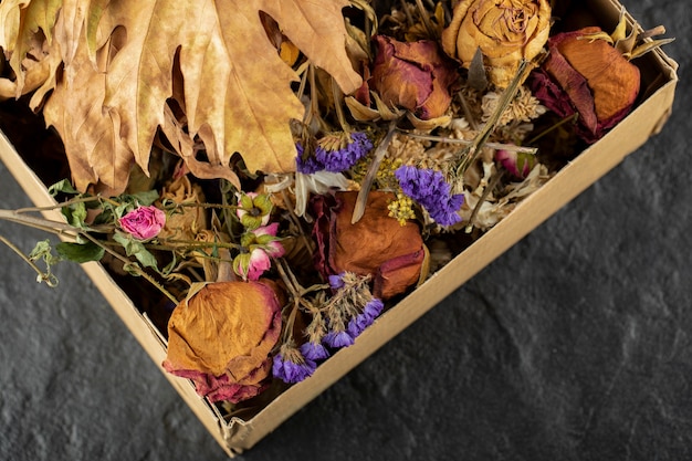 Dried roses flowers with dried leaves in a paper box . 