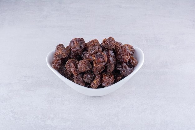 Dried sour cherries in a cup on concrete background. High quality photo