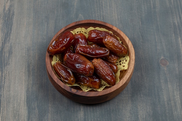 Free photo dried tasty dates in a wooden bowl